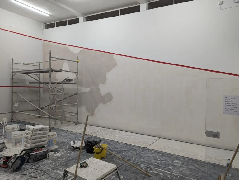Plaster squash court wall showing surface wear and renovation