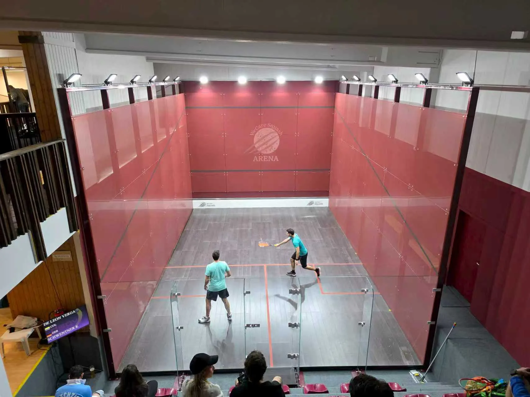 Active squash court with players and spectators